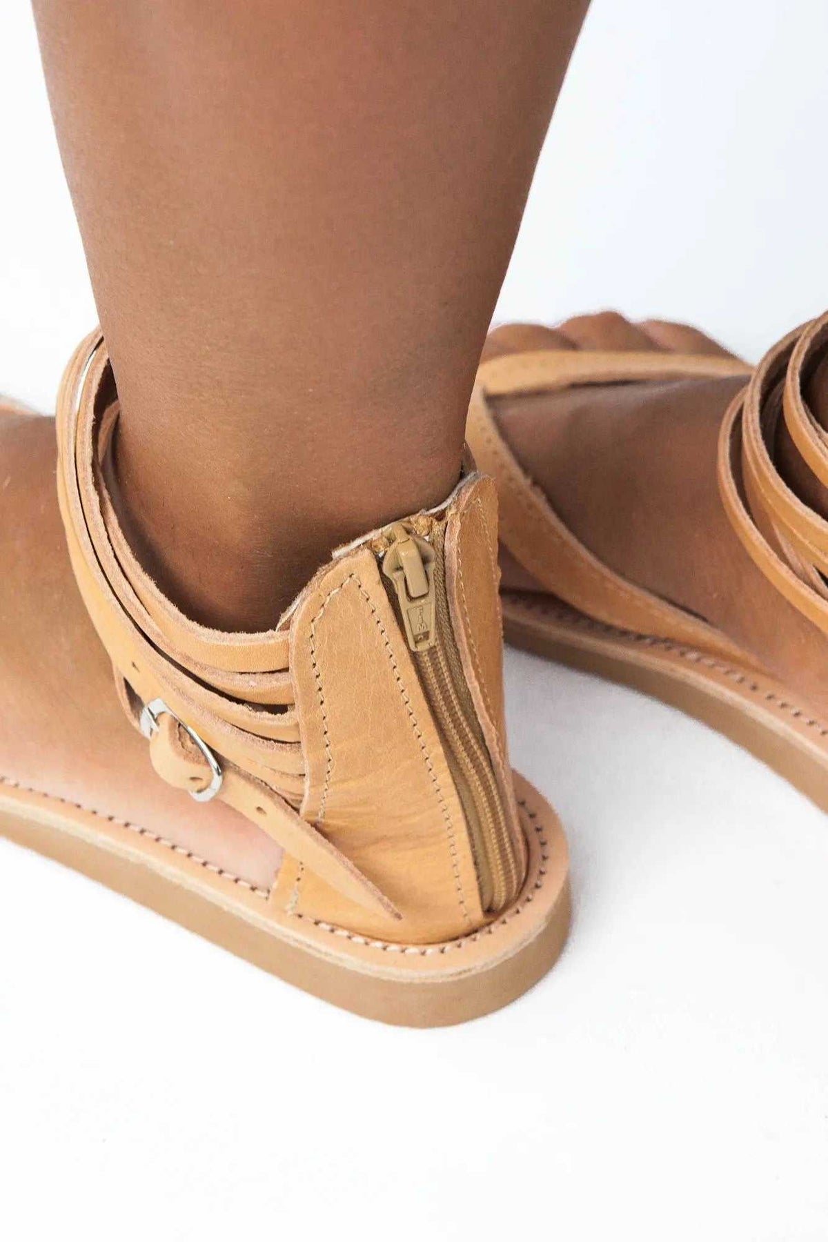 ERMIS Handmade Greek Sandals in natural tan leather with ankle straps, a side zipper, buckle, and flat sole