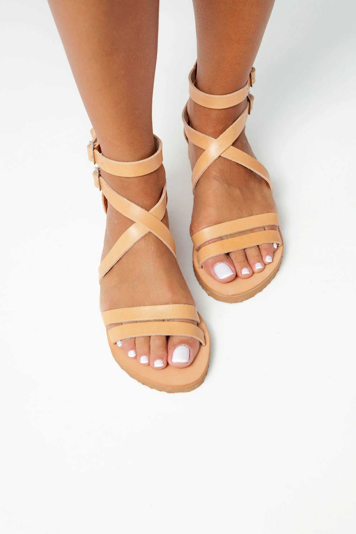 IOS Handmade Greek Sandals in tan leather, with crisscross ankle straps, buckle fastenings and flat soles.