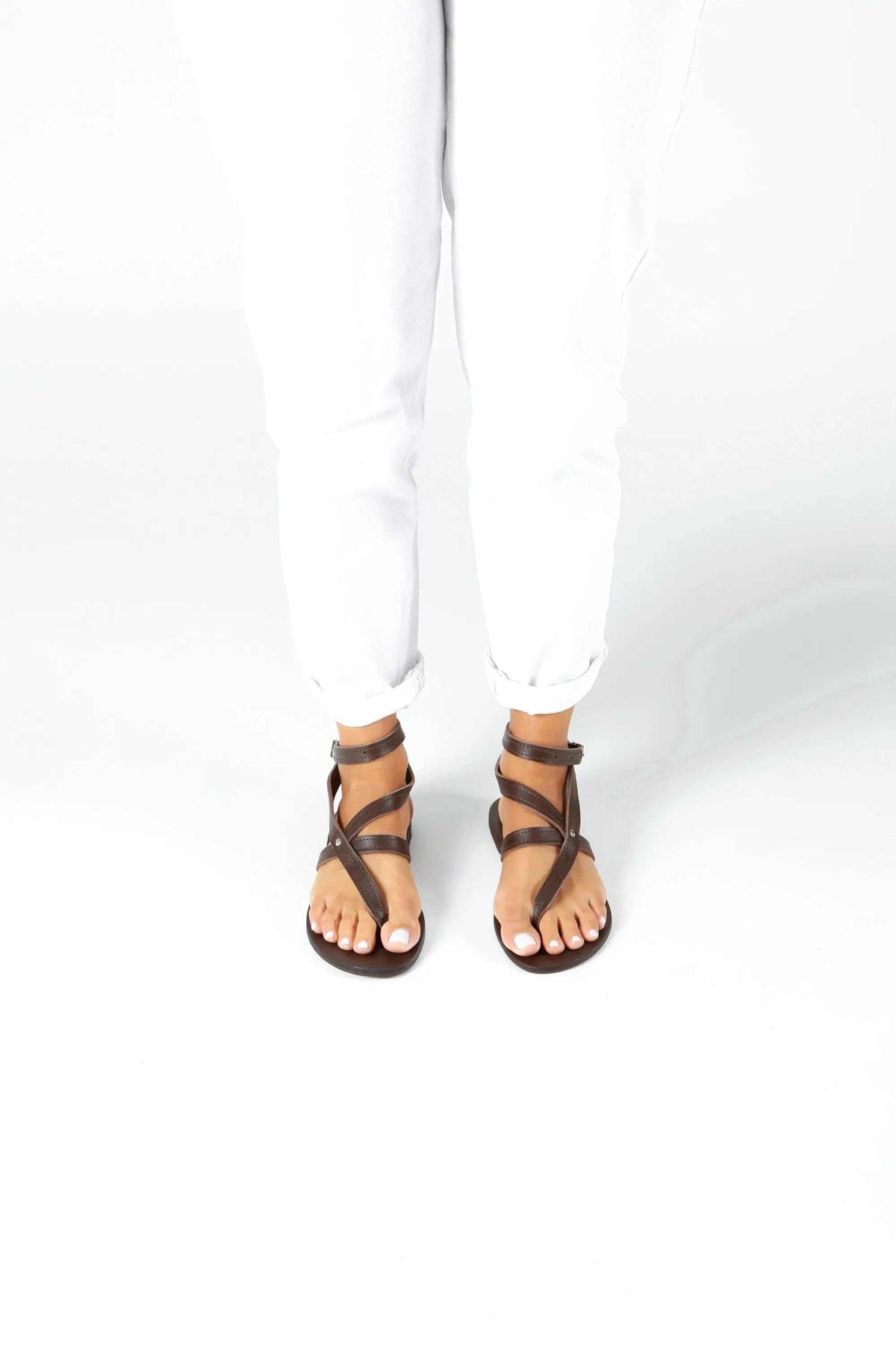 IRA Handmade Greek Sandals in brown leather with slim crisscross straps, ankle cuffs and dark soles