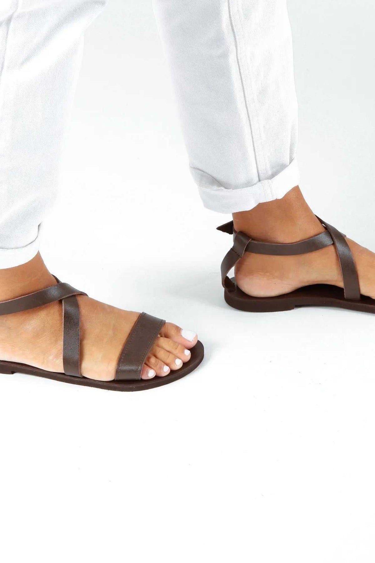 MYRTO Handmade Greek Sandals in dark brown leather with slim crossed straps, toe loops and flat soles