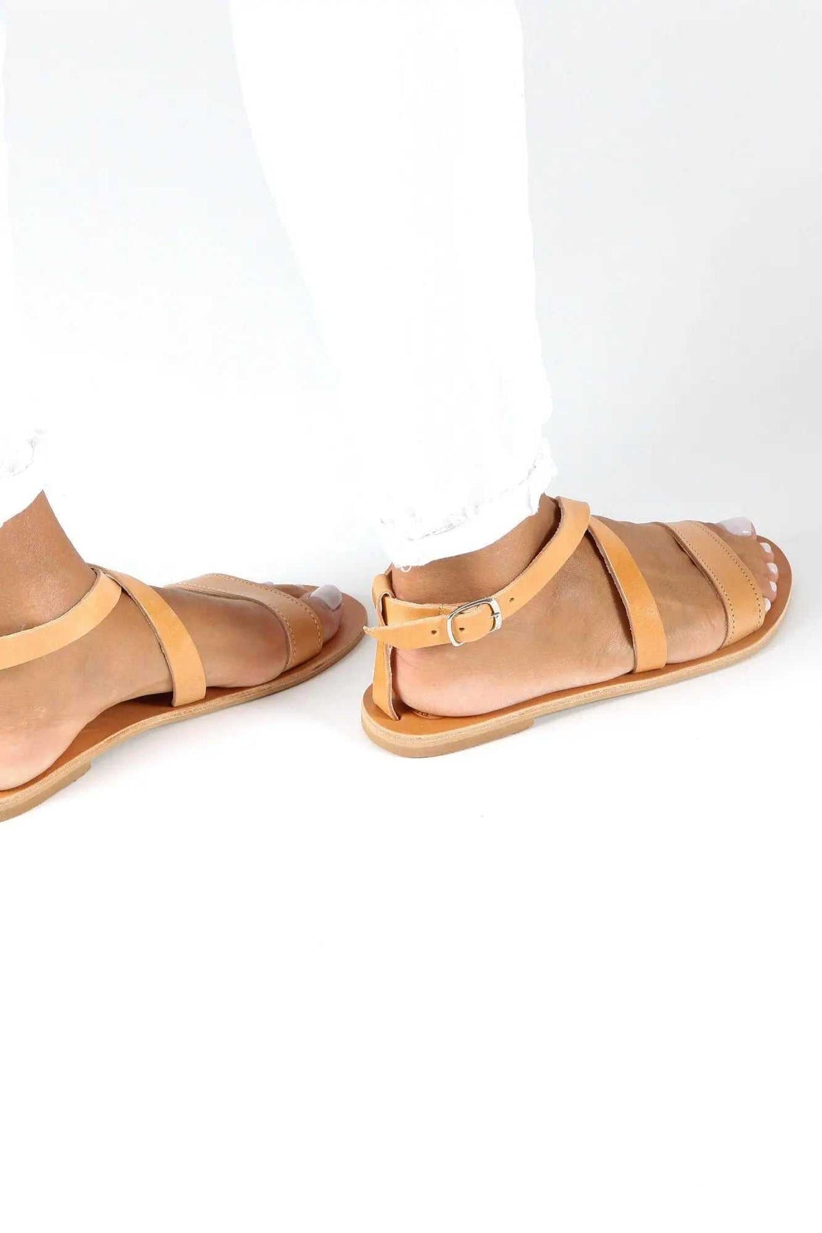 MYRTO Handmade Greek Sandals in natural tan leather with layered straps, buckled ankle closures and flat soles