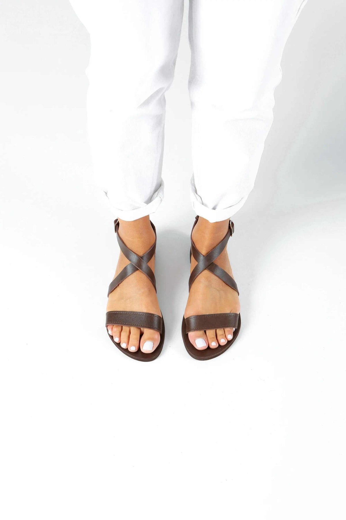 MYRTO Handmade Greek Sandals in natural tan leather with dark brown crossed straps and a simple open-toe design