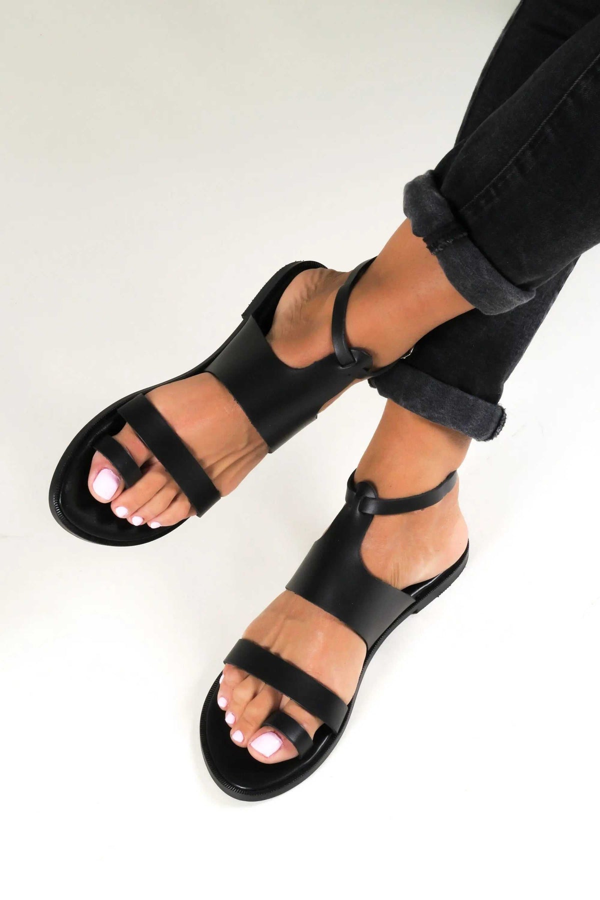 NIKEA Handmade Greek Sandals in black leather with wide straps, ankle buckles, and open-toe design