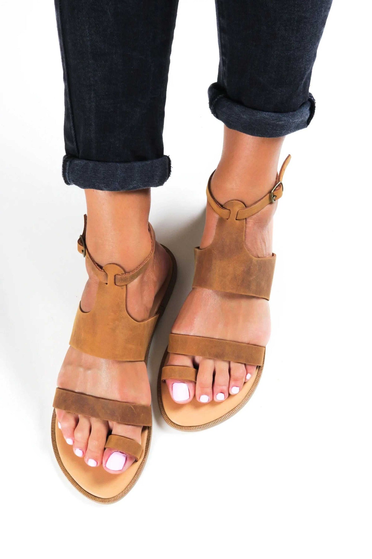 NIKEA Handmade Greek Sandals in tan leather with wide straps, ankle buckles, and open toes
