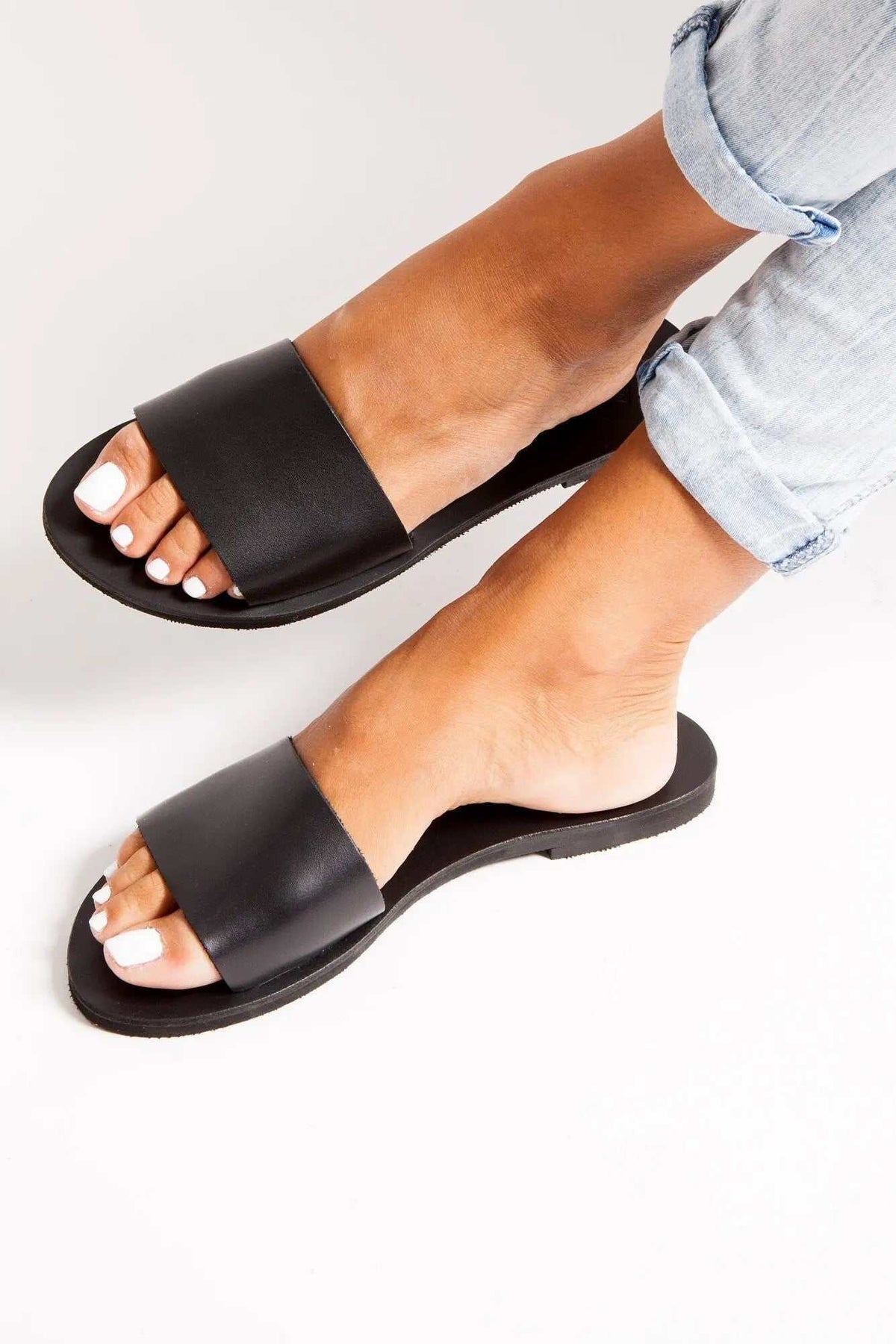 PAROS Handmade Greek Sandals in black leather, featuring wide slip-on straps, open toes and flat soles.