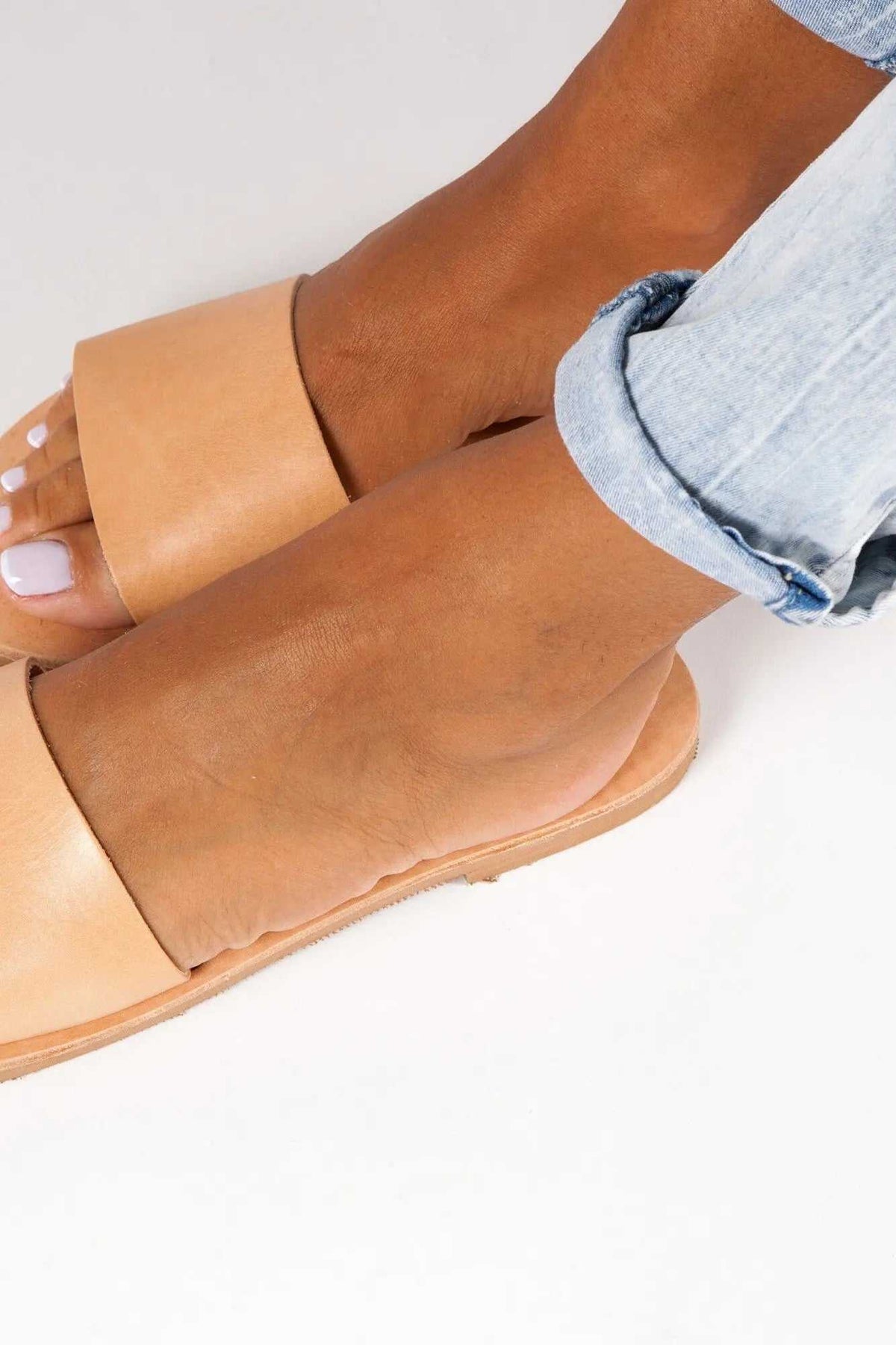 PAROS Handmade Greek Sandals in natural tan leather, featuring wide slip-on straps, flat soles and a simple design