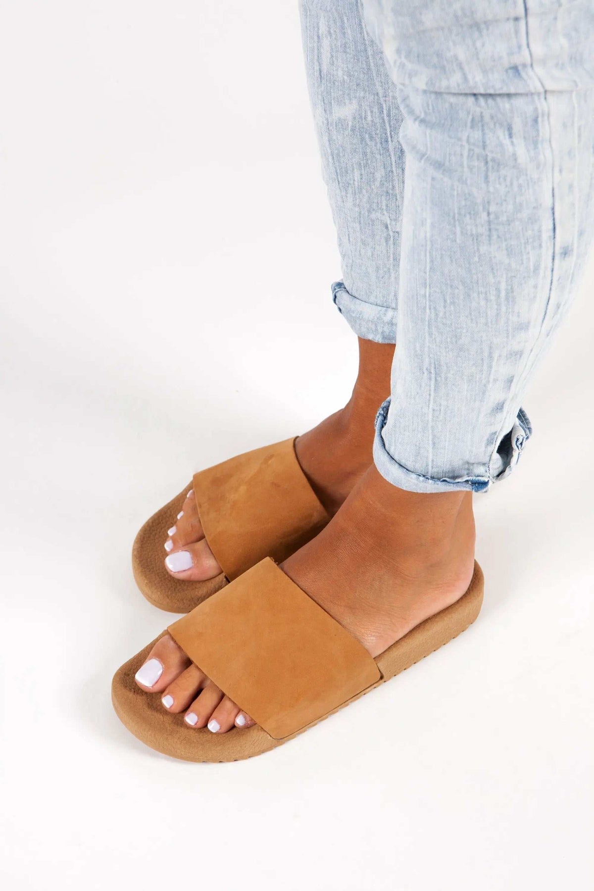 POSEIDON Handmade Greek Sandals, tan leather slides with broad crossover straps and flat textured soles.