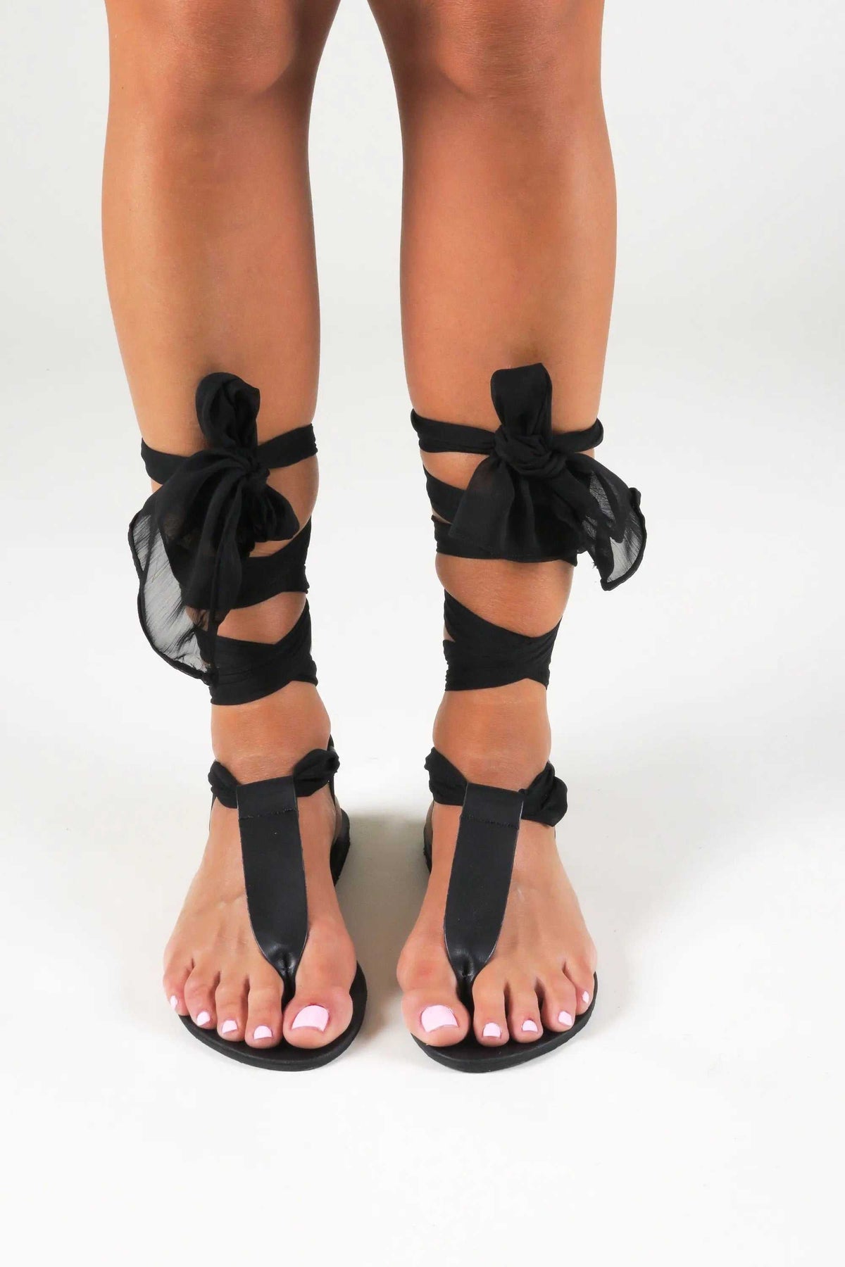 ROMEIKOS Handmade Greek Sandals in black leather with gladiator straps and scarf laces tied around the ankles