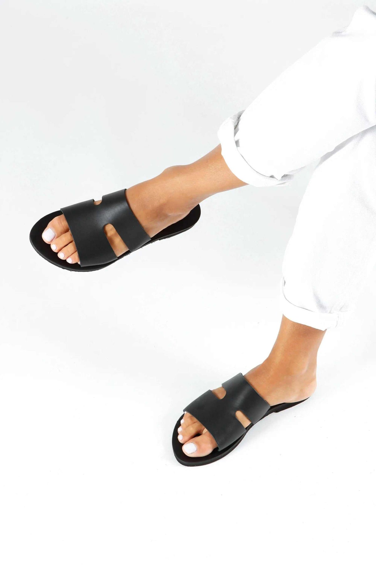 VOTSALO Handmade Greek Sandals in black leather with flat soles and wide straps featuring two cutout details