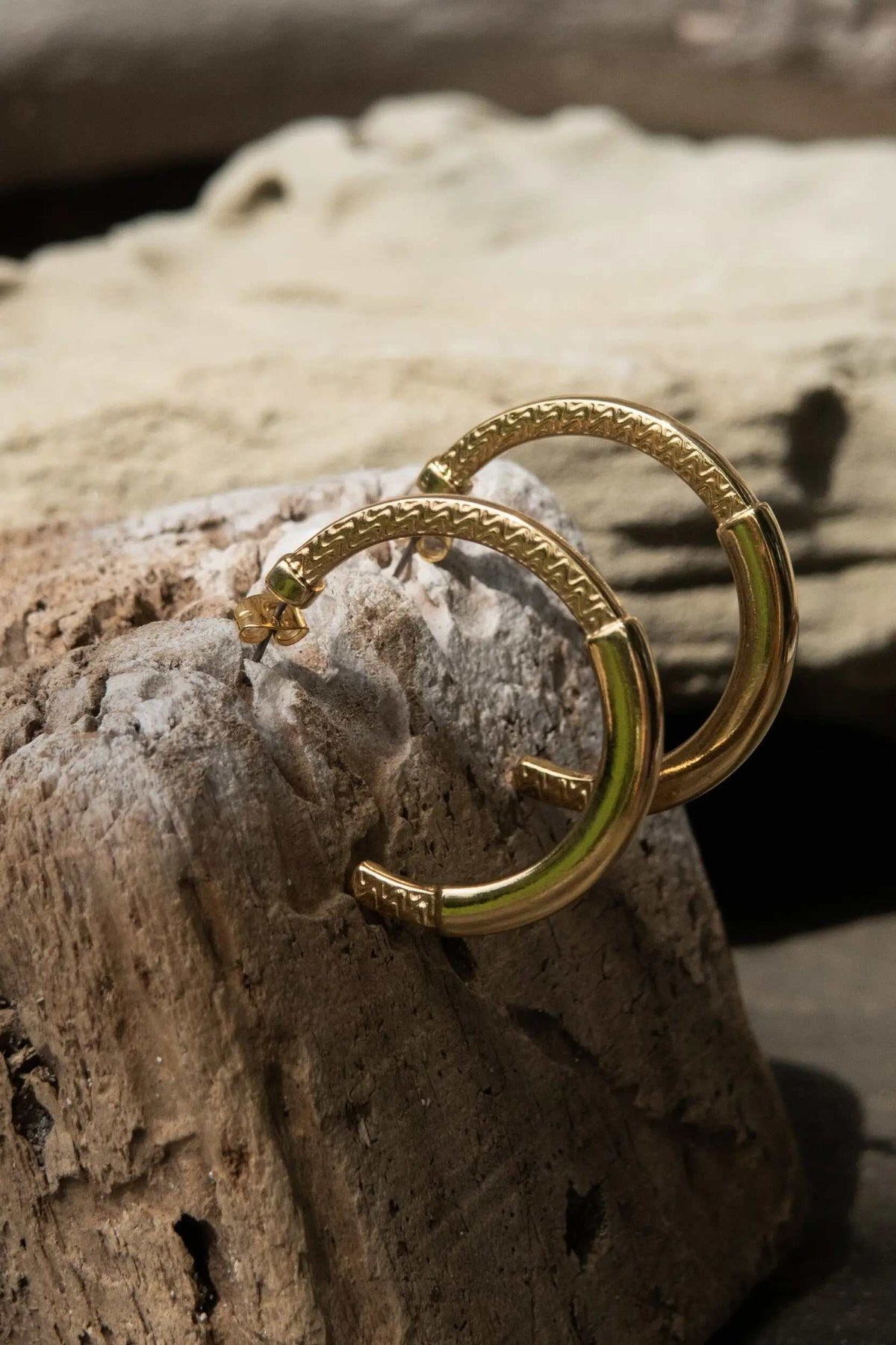 24 k gold filled hoops in a warm gold tone, with textured tribal-pattern bands and hinged closures