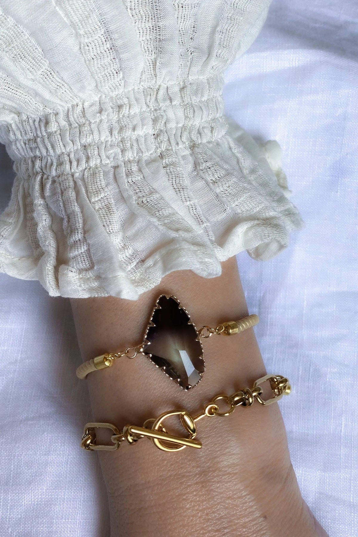 Adjustable Crystal Bracelet with a dark brown faceted crystal, gold-tone setting and adjustable cord with gold accents