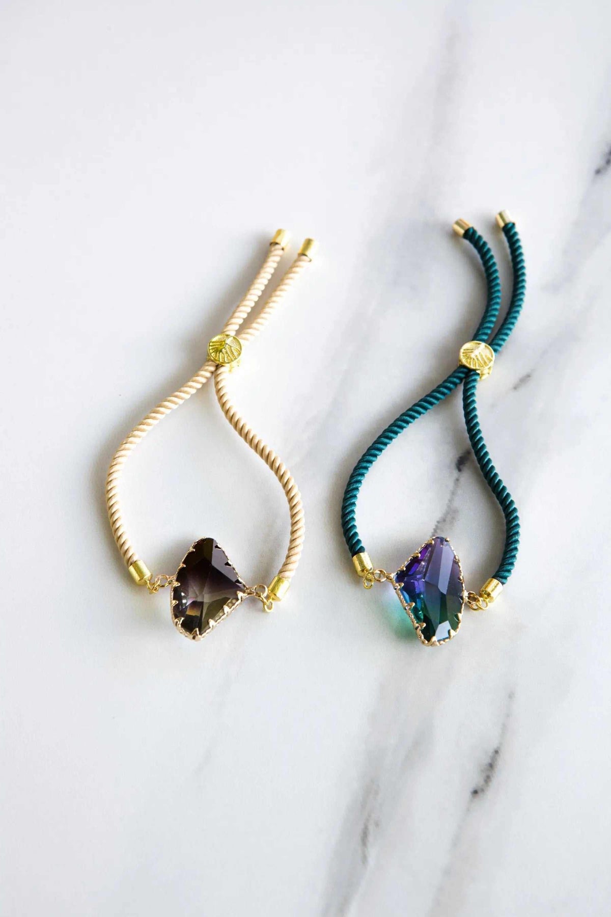 Adjustable Crystal Bracelet with faceted dark crystal, gold-tone fittings, and twisted cream or teal cord