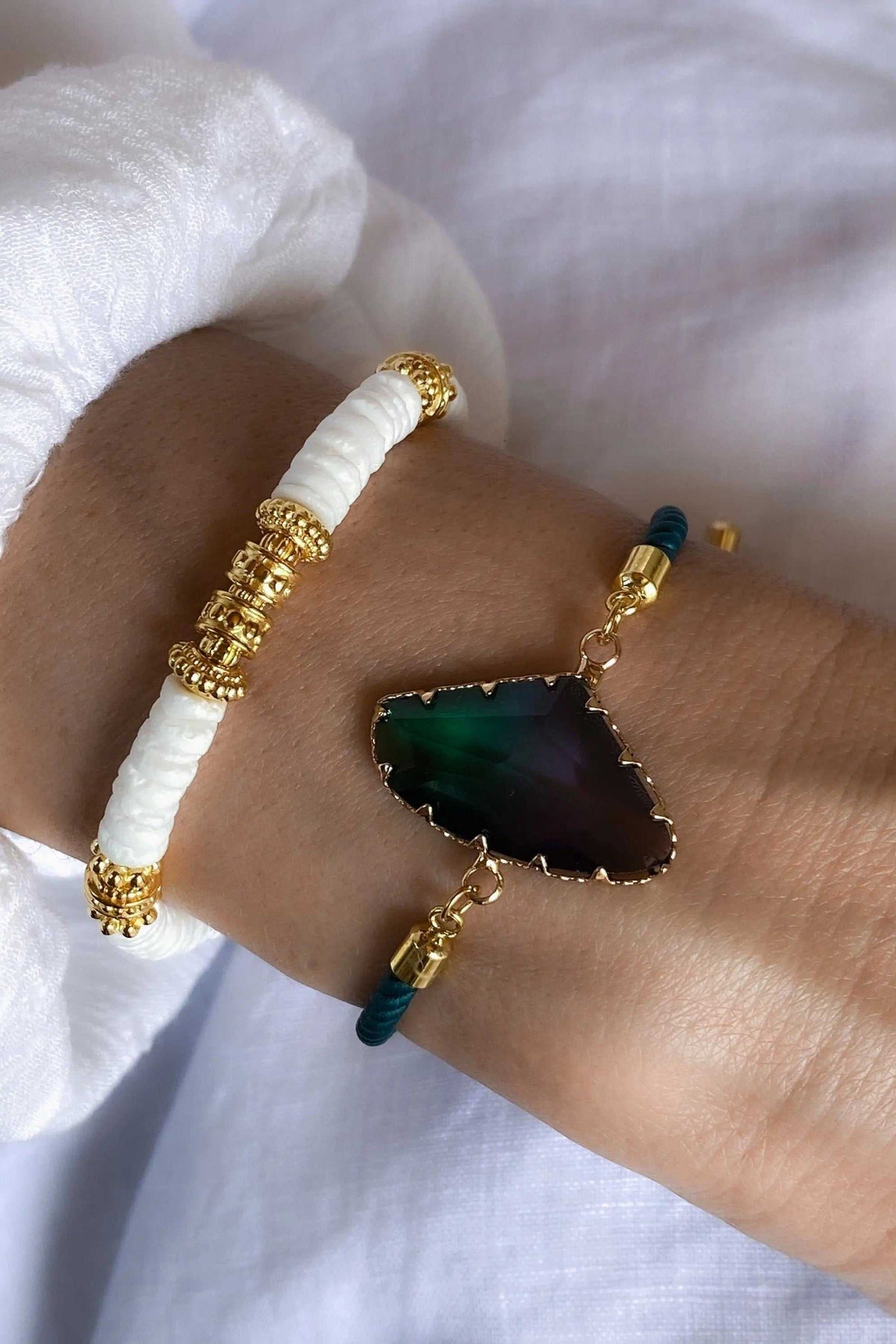 Adjustable Crystal Bracelet with a dark green faceted crystal edged in gold, teal cord, and gold-tone fittings