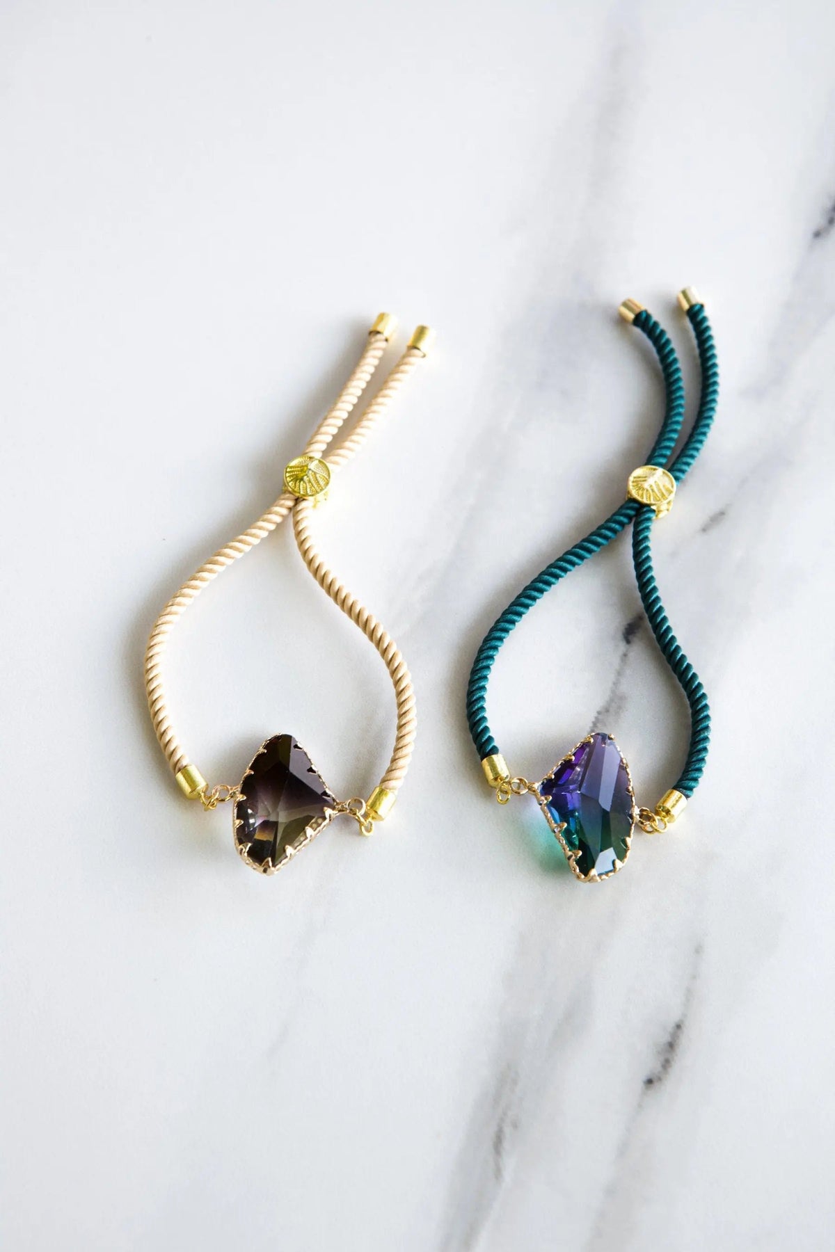 Adjustable Crystal Bracelet with twisted cream or teal cord, gold-tone fittings and faceted dark purple crystal centerpiece