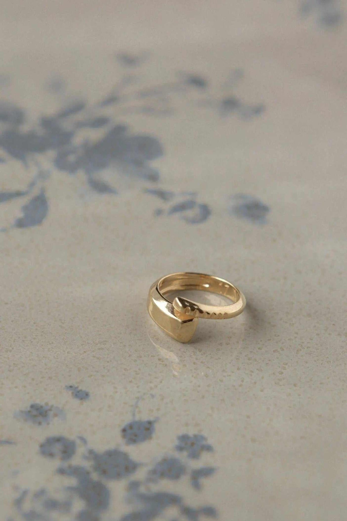 Adjustable Gold snake ring in polished gold-tone metal, featuring a sculpted serpent head and gently open adjustable band