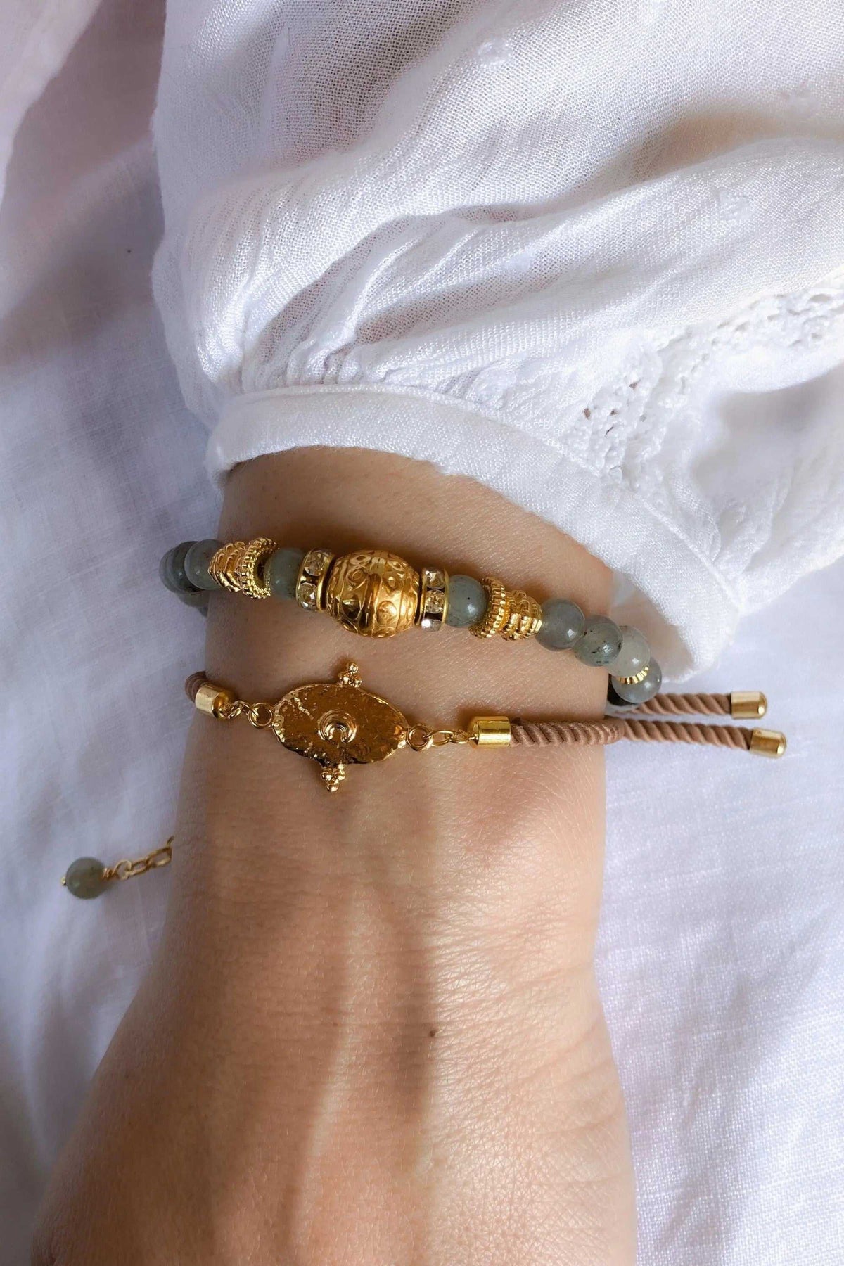 Adjustable rope Bracelet with gold-tone tribal centerpiece, tan braided cord, and muted green round beads