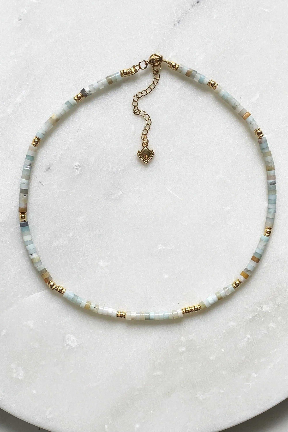 AELIA NECKLACE with pale aquamarine beads, gold-plated details, and an extender chain with pendant