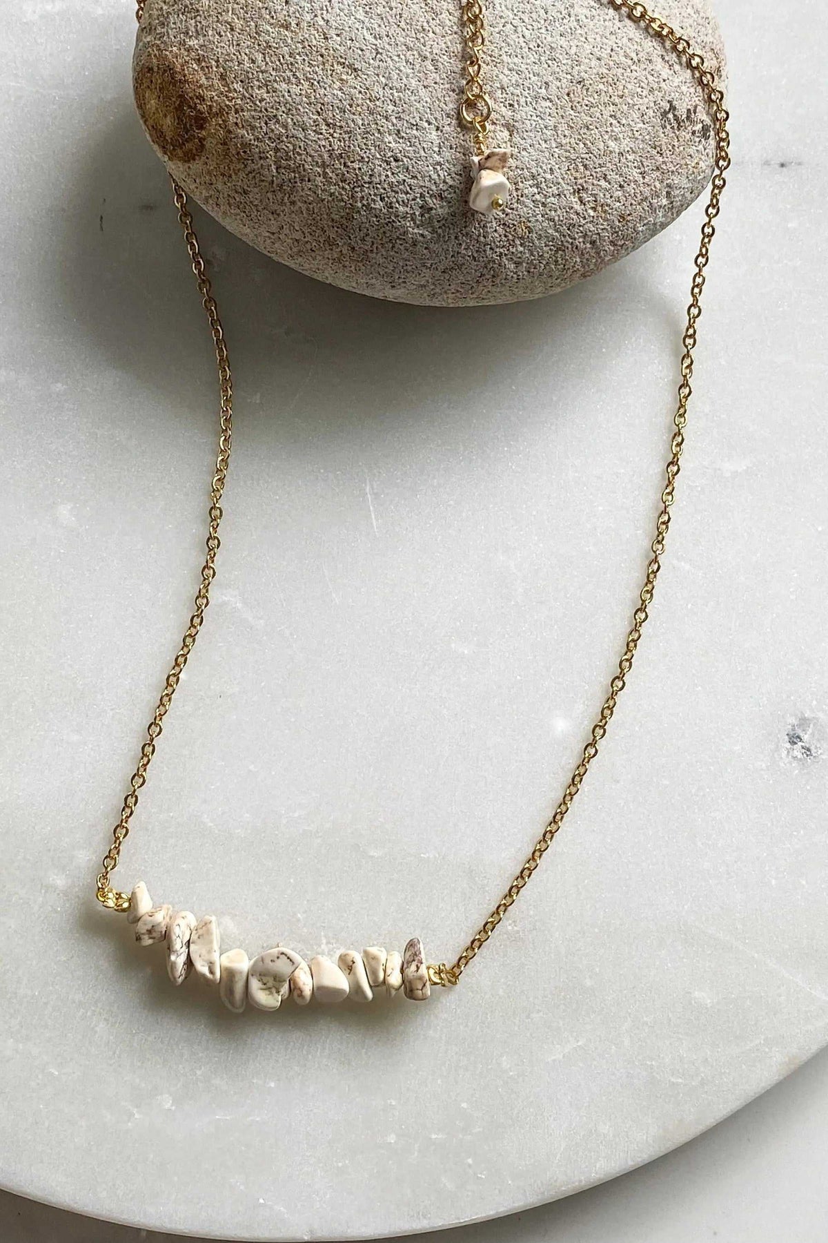 AFRODITA EARRINGS with a gold-tone chain and irregular cream-white stone chips along the front