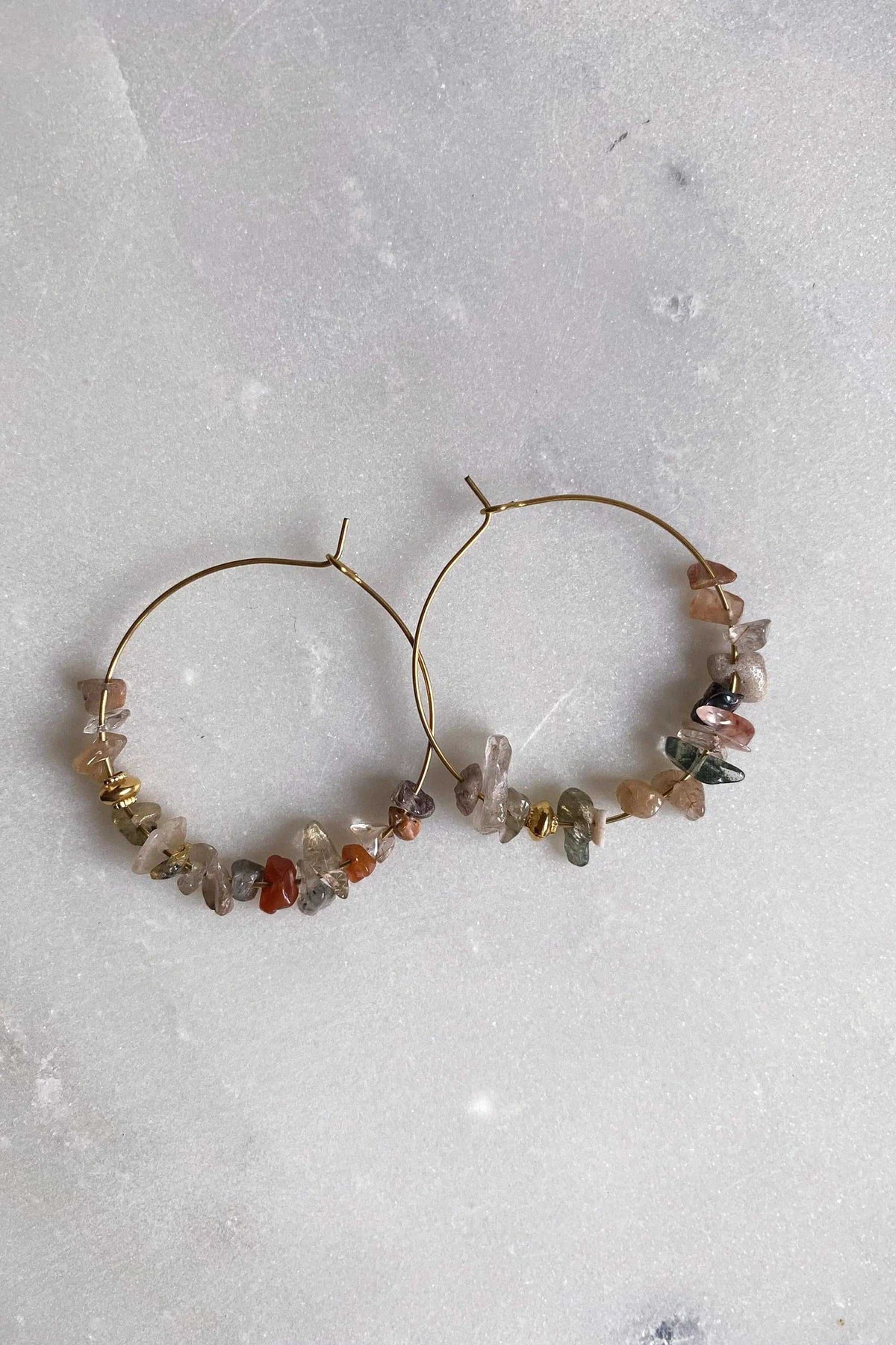 AFRODITA EARRINGS are thin gold-tone hoops with multicoloured natural stone chips clustered along the lower curve