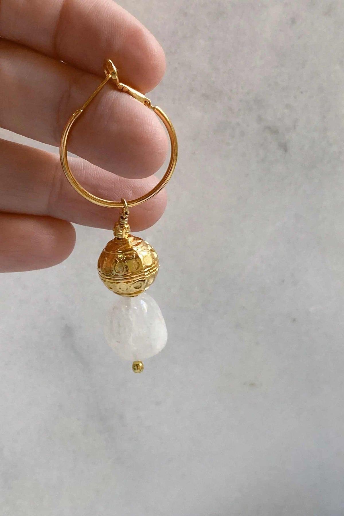 AGAPE EARRINGS gold-tone hoop earring with ornate round charm and dangling clear quartz stone