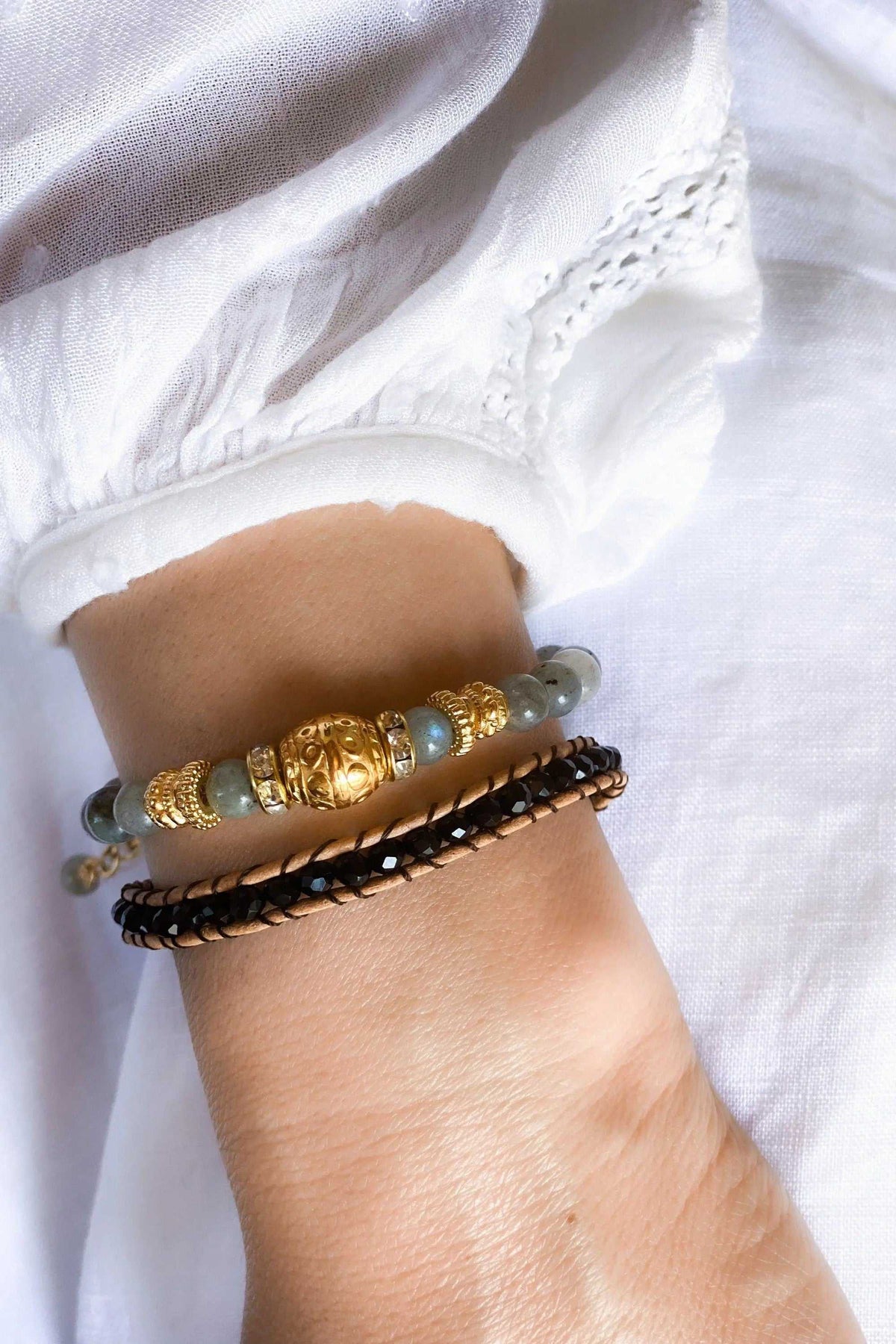 AGAPI BRACELET with black braided leather, gold-tone and pale blue beads, and a decorative central gold bead