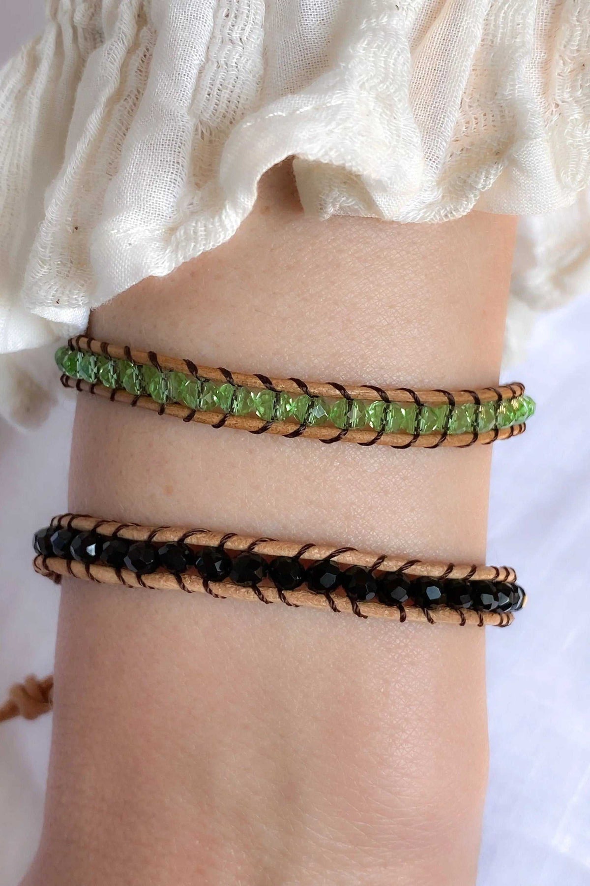 AGAPI BRACELET in brown leather with green and black crystal beads, shown as two slim woven strands