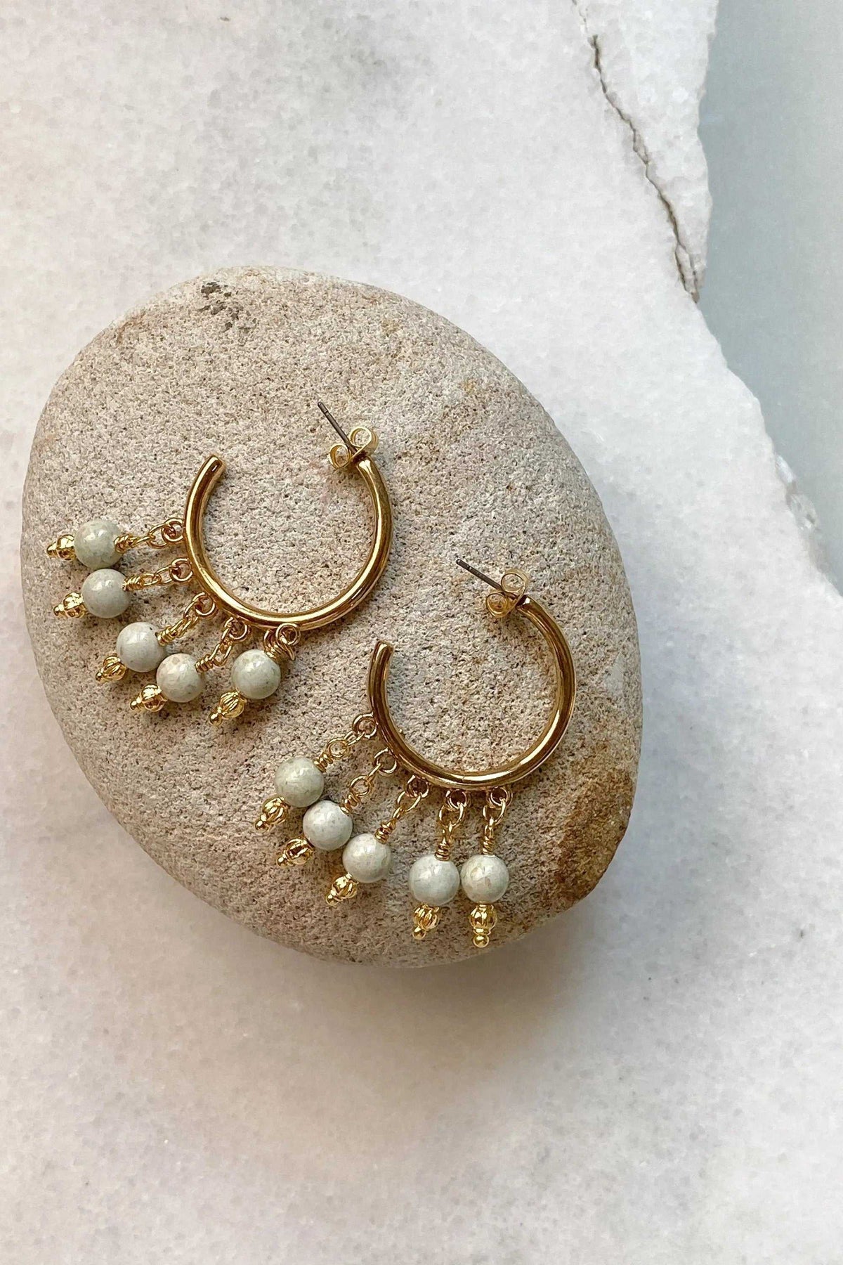 ALEX EARRINGS are gold-tone hoop earrings with dangling white round beads and delicate gold chain details