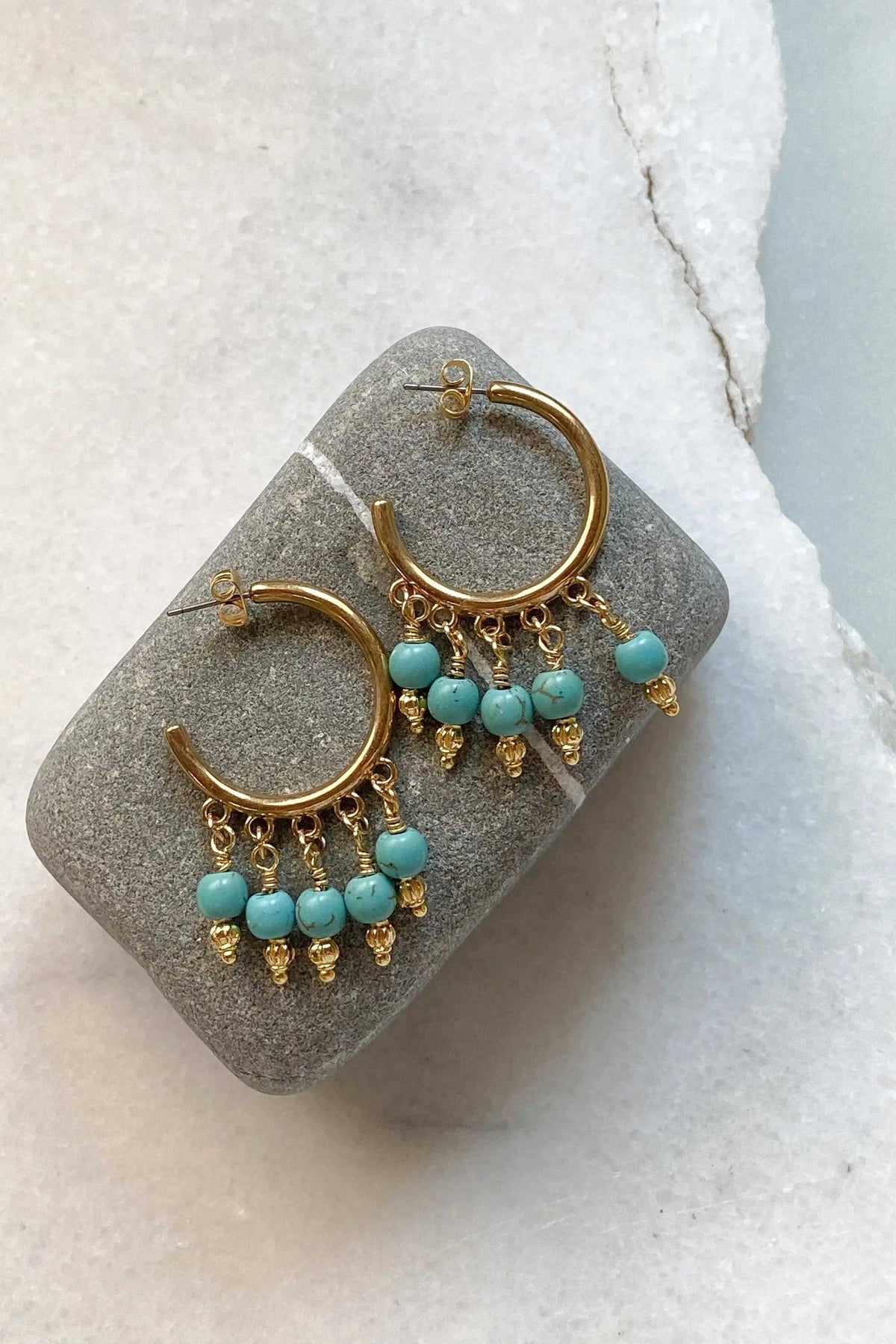 ALEX EARRINGS are gold-tone brass hoop earrings with turquoise blue beads and dangling gold charms