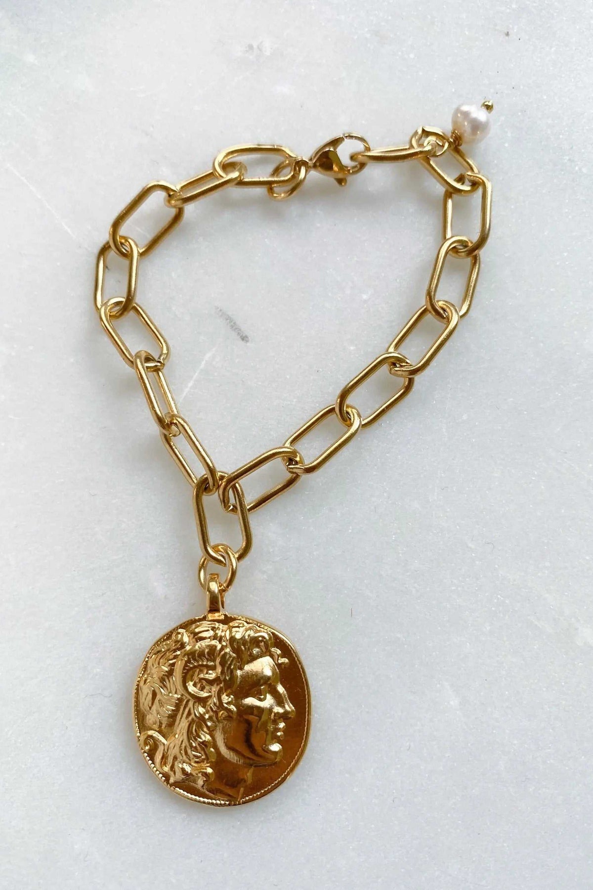 Alexander Charm Bracelet with a gold-tone chunky oval-link chain and round sculpted classical face coin pendant.
