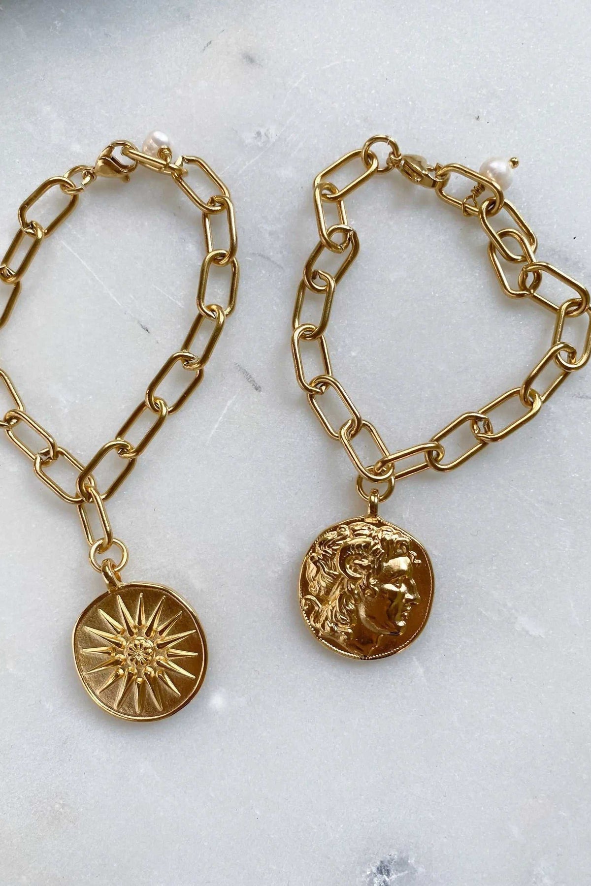 Alexander Charm Bracelet in gold-tone chunky oval-link chain with round pendants, one featuring a sunburst and one a classical face