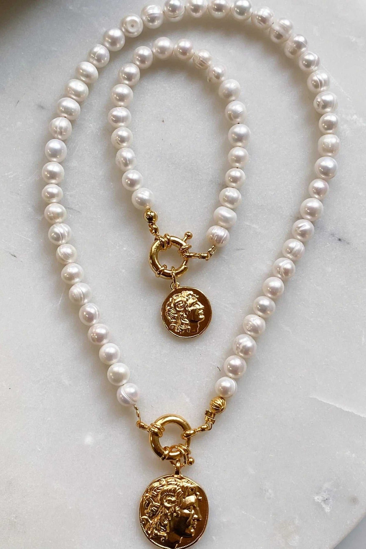 Pearl bracelet with glossy white freshwater pearls, gold-tone fittings and a coin charm depicting Alexander the Great
