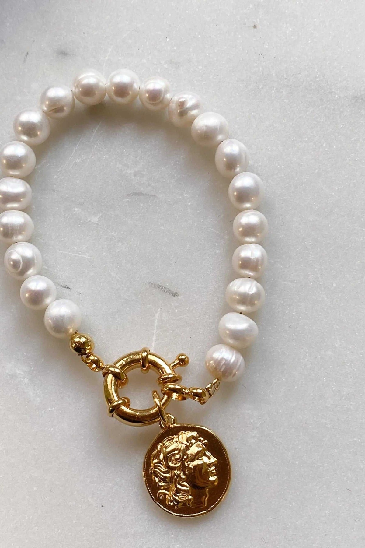 Pearl bracelet featuring lustrous white freshwater pearls, a gold-tone clasp and coin pendant depicting Alexander the Great