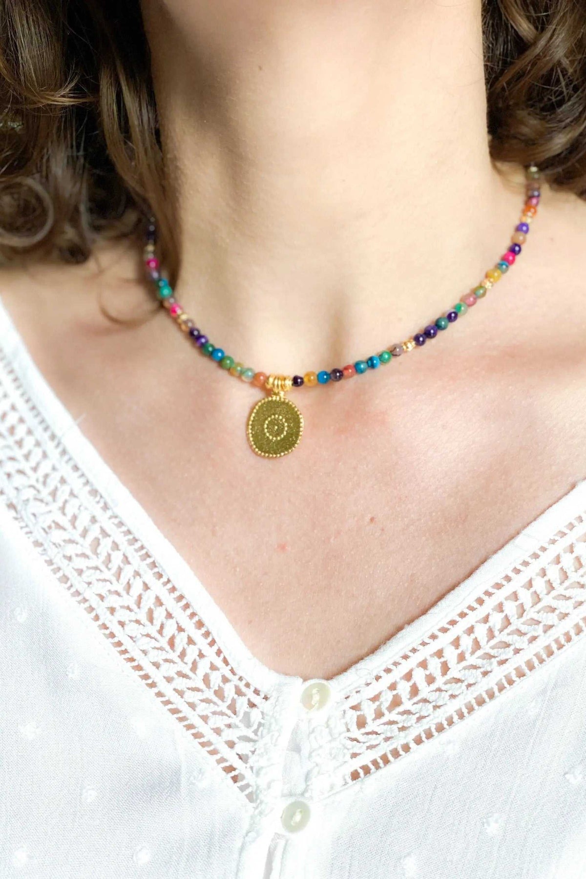 ALKYONI NECKLACE with multicolour beaded strand and gold-toned circular pendant featuring an evil eye motif