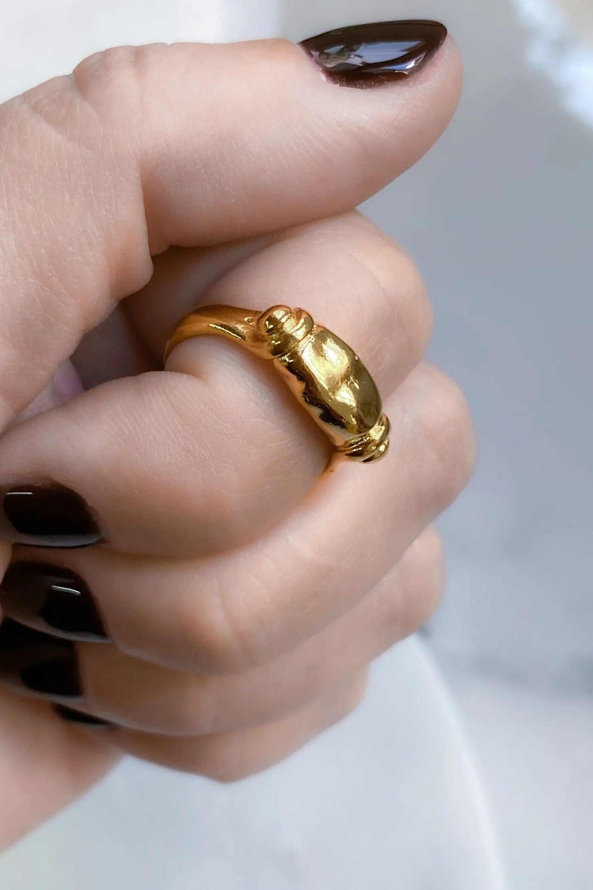 Ancient Greek ring in gold with a sculpted beetle motif and textured band, worn on a finger