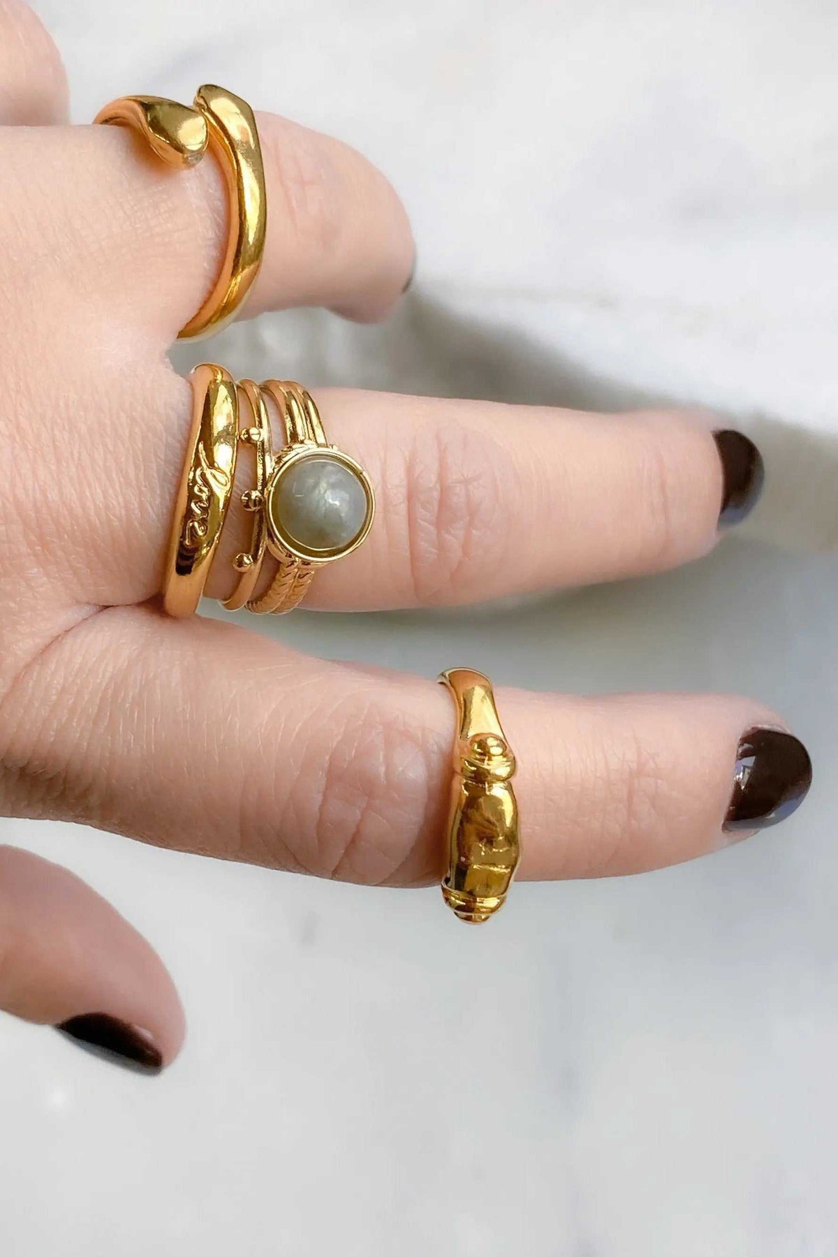 Ancient Greek ring set in gold-tone metal, including twisted bands, engraved details and a round pale grey stone