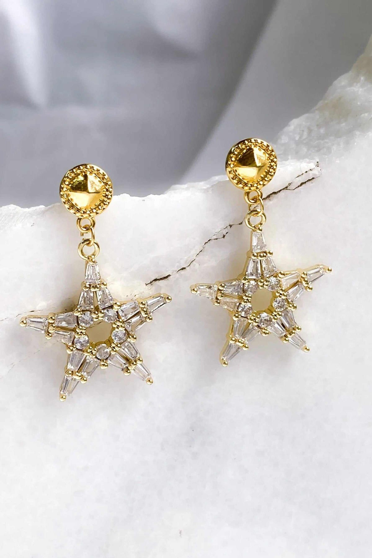 ANDROMEDA Earrings with gold-tone round studs and dangling five-point stars set with clear sparkling stones.