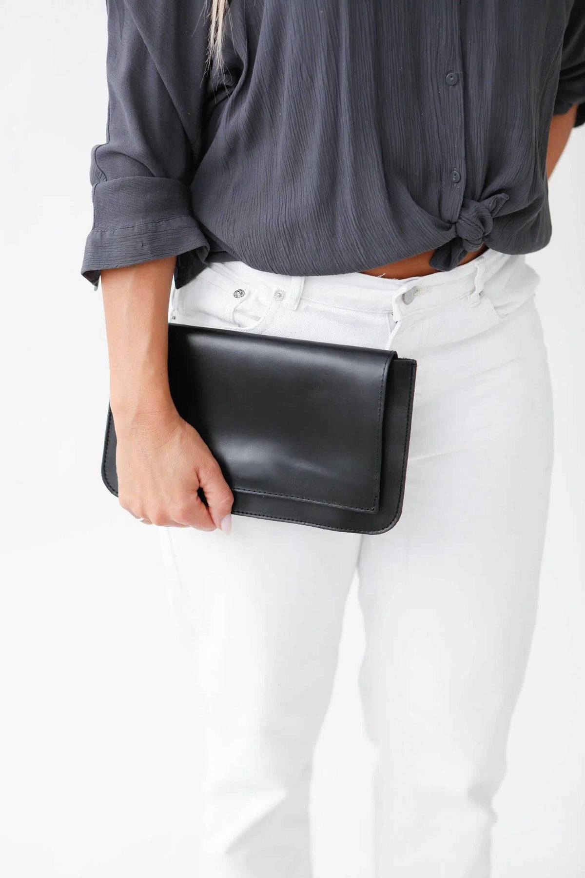 ARION envelope clutch bag in smooth black leather with a large front flap and clean, structured edges