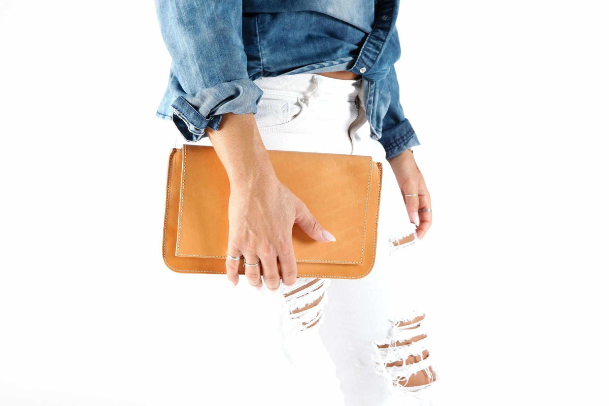 ARION envelope clutch bag in tan leather with a large stitched flap and clean structured shape