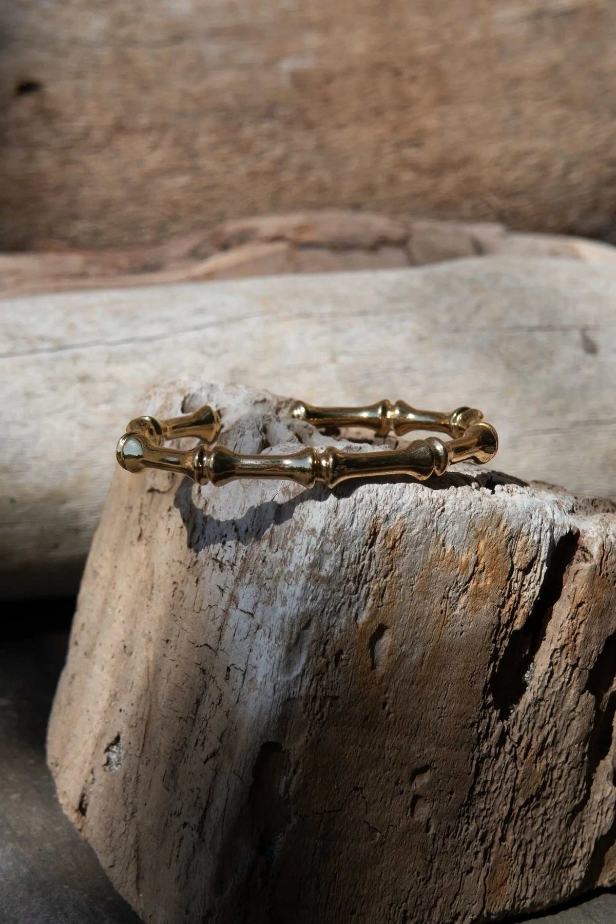 Bamboo pattern bracelet in polished gold-tone metal, formed from linked bamboo-like segments with rounded joints