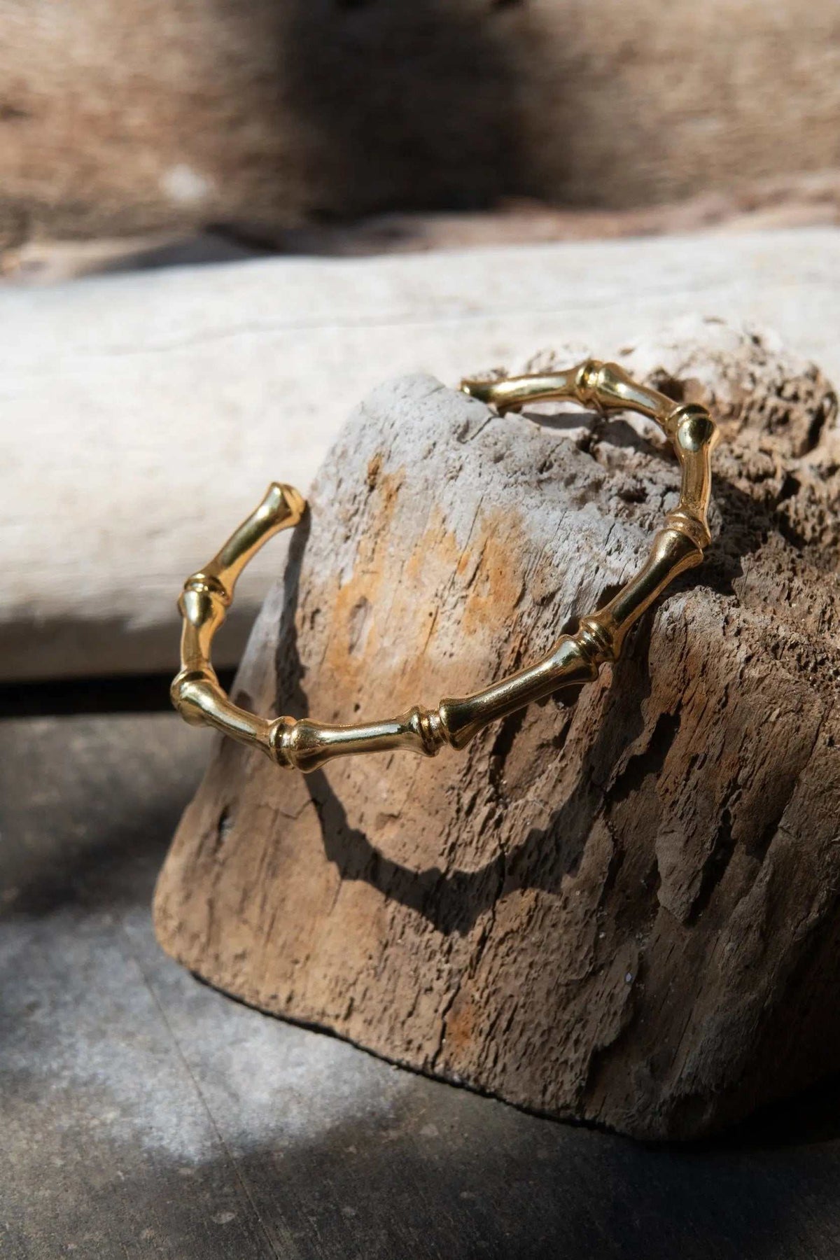 Bamboo pattern bracelet in gold-tone metal, formed from slender segmented bamboo-like links with rounded joints