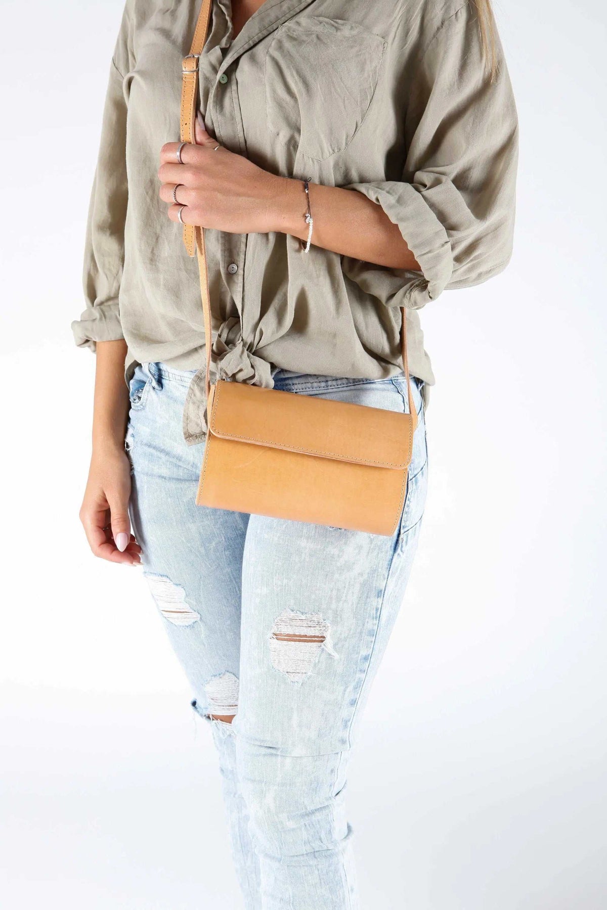Barrel Bag in camel leather with a rectangular flap, long adjustable strap, and minimalist shoulder design
