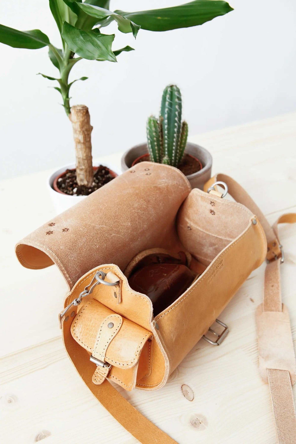 BARREL BAG with pockets in natural tan leather, featuring a cylindrical shape, open top, and adjustable strap