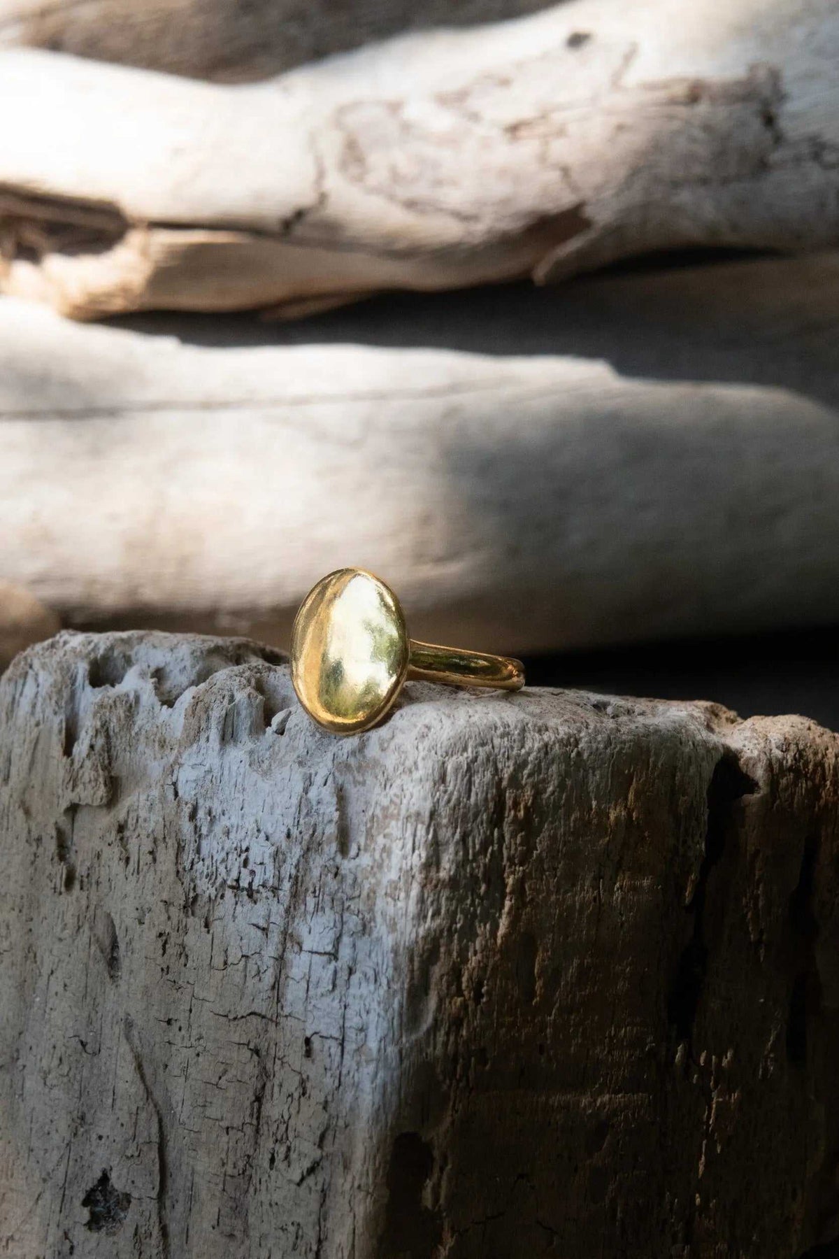 BIG Round RING in polished gold-tone metal, featuring a large smooth oval face and slim adjustable band.