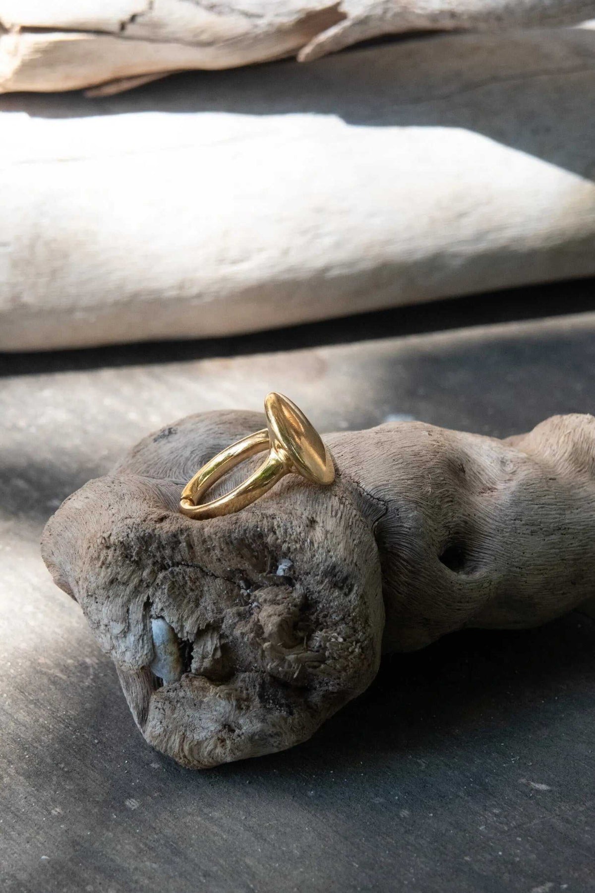 BIG Round RING with a polished gold-tone finish, featuring a smooth oval top and an open adjustable band