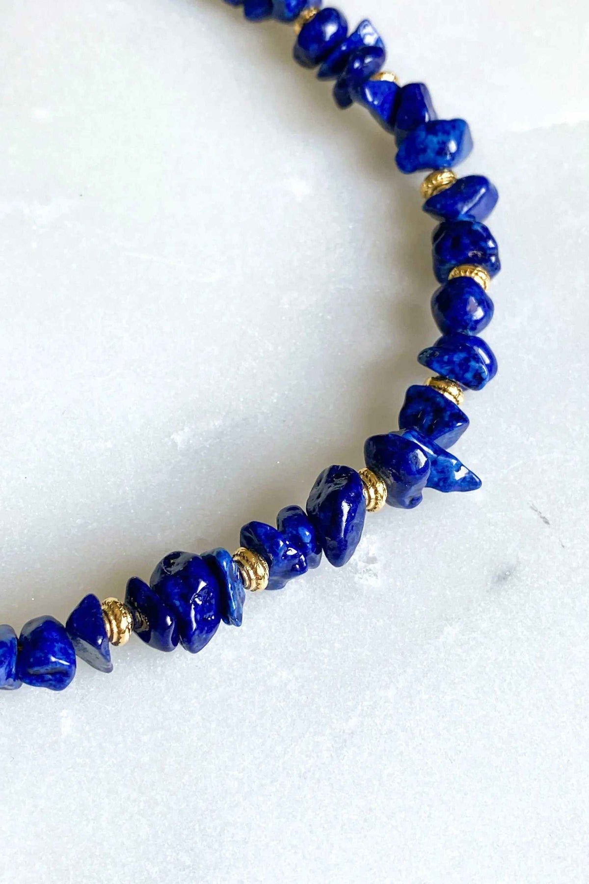 Blue Jade necklace with deep blue irregular stone beads and gold-toned spacer details