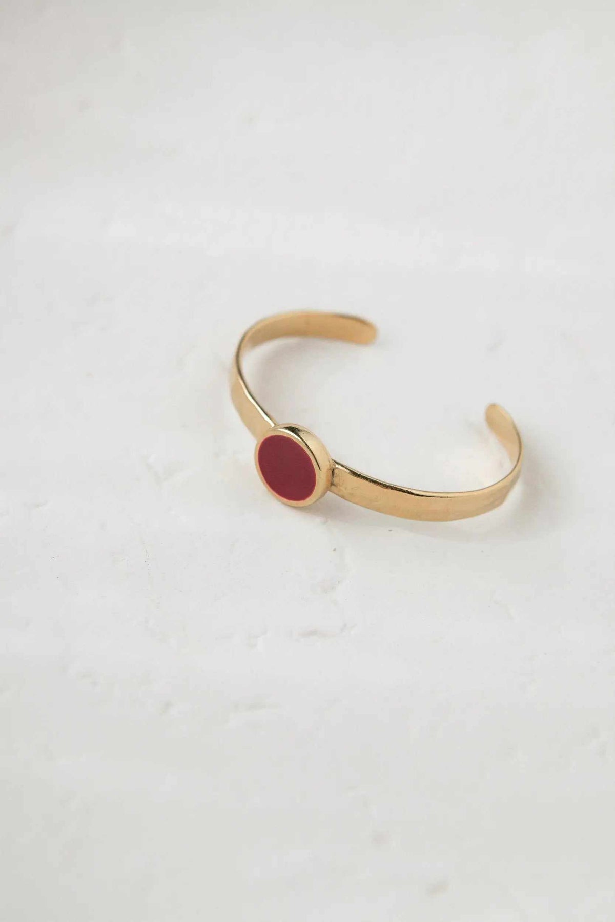 Bracelet femme or, a gold-tone open cuff with a smooth finish and a red circular resin centerpiece.