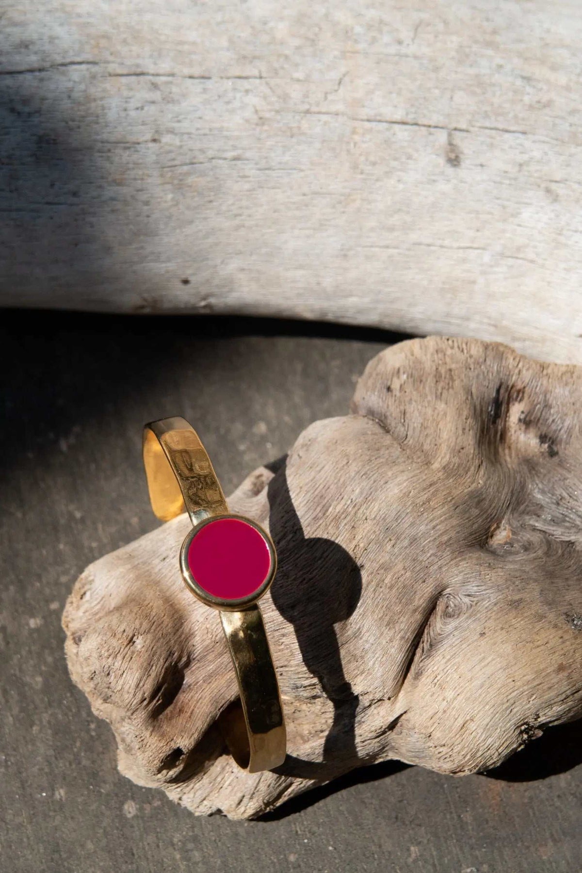 Bracelet femme or gold-tone hammered metal cuff with a vivid magenta circular enamel centerpiece and narrow band