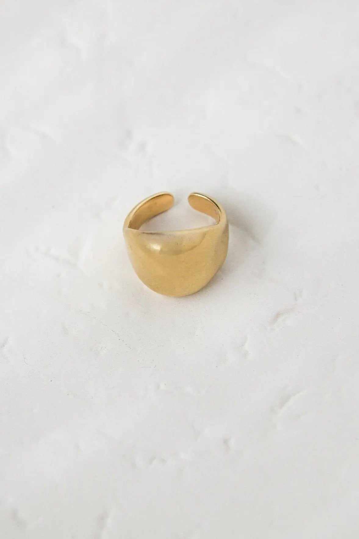 Chunky bold RING in polished gold-tone metal, with a wide rounded band and adjustable open back