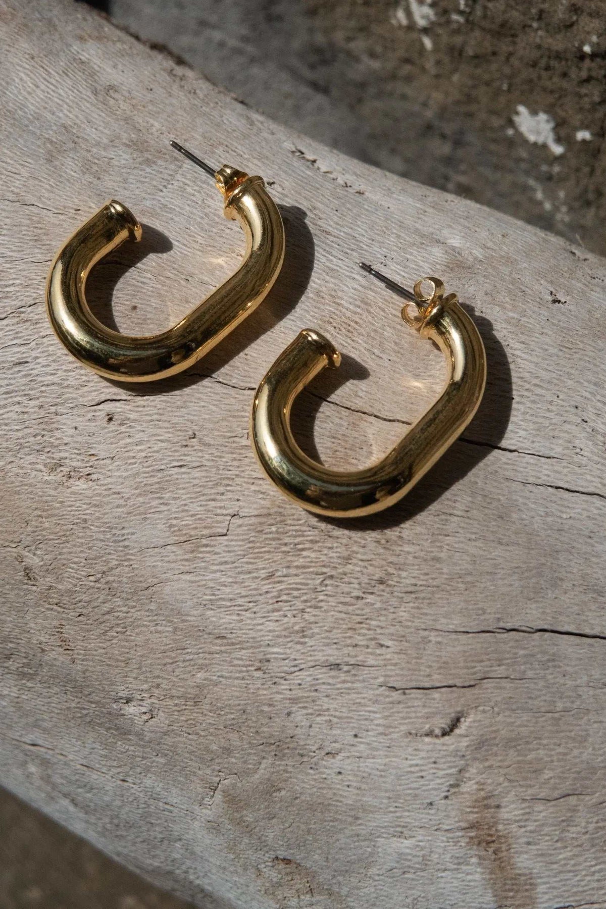 Chunky chain Hoops in polished gold-tone metal with thick curved links and titanium posts