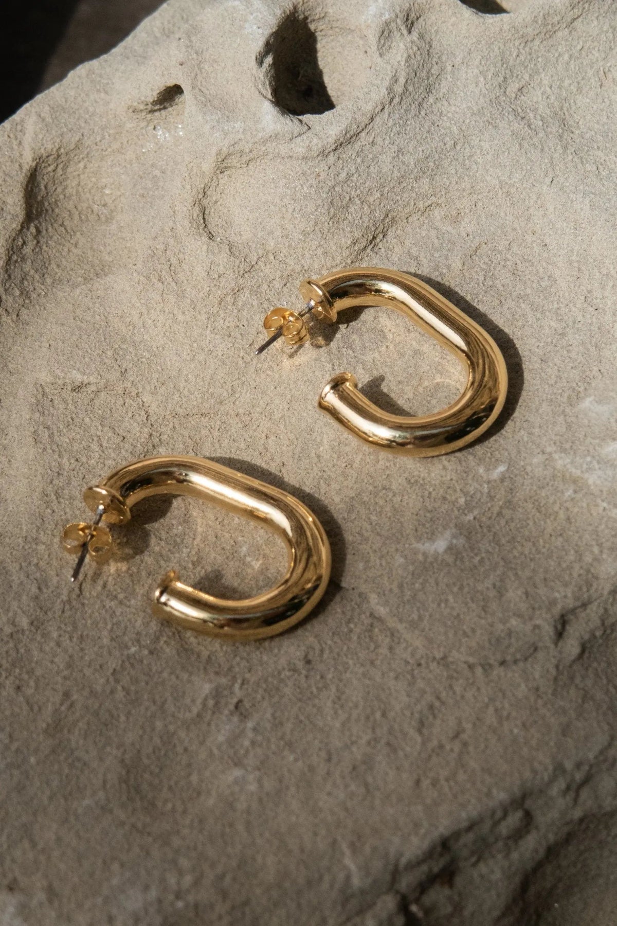 Chunky chain Hoops in polished gold-tone metal with rounded linked curves and secure pin closures